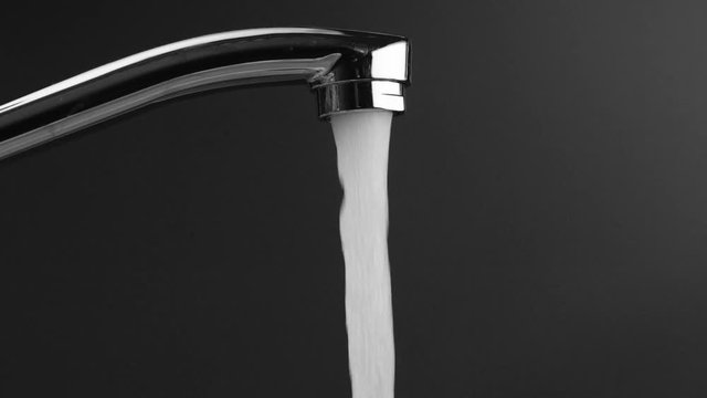 water flows from the tap on a grey background, then the water stops