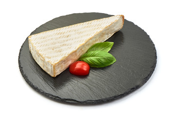 Fresh Brie cheese on a slate shale plate, French Camembert cheese, close-up, isolated on white background