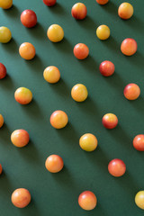 Abstract food pattern. Raw plum fruits on deep green background..