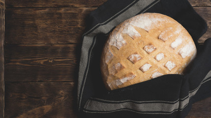 Baked bread on a wooden table background.