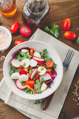 Salad with cherry tomatoes, radsh and mozzarella, lettuce mix