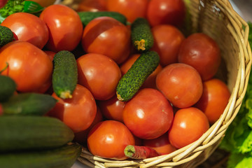 Fototapeta na wymiar Basket with fresh vegetables, organic cucumbers tomatoes. Farmers market