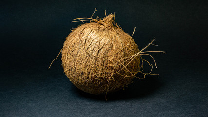 Exotic fruit Coconut, fruit in the shell, dark background, selective focus, selective light, close-up