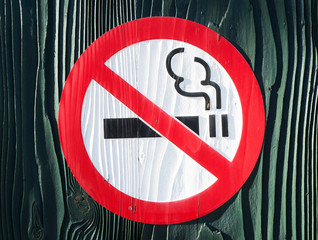 Non smoking sign carved in wood.