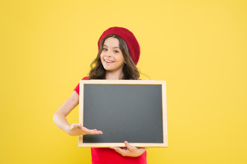 big sales. child on yellow backdrop. back to school. Interesting info. happy girl in french beret. small girl kid with school backboard, copy space. information board. Fashion news. place for writing