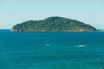 Vista para o paraíso, é possível ver a ilha ao fundo e uma embarcação com pescadores.