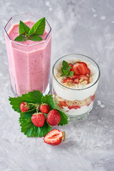 Strawberry milk shake in a glass jar and fresh strawberries with leaves
