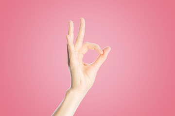 Positive gesture on a pink background. Hand show okay sign, close up