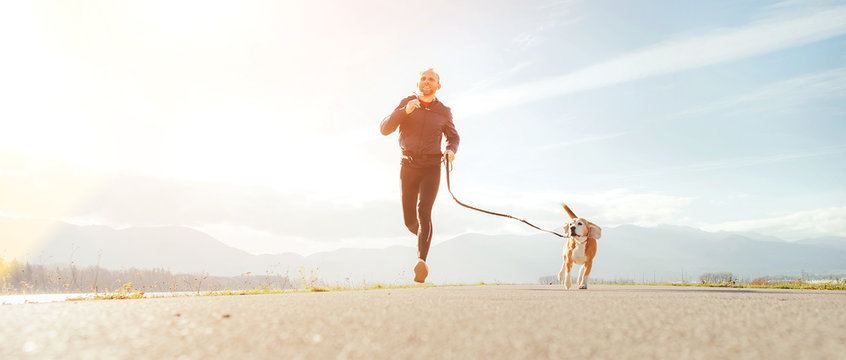 Jogging man with his dog in the morning. Active healthy lifestyle concept image.