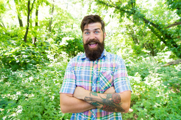 Naklejka na ściany i meble Eco lifestyle. Man bearded hipster green trees background. Guy relax in summer nature. Man beard and mustache in summer forest. Summer vacation concept. United with environment. Handsome lumberjack