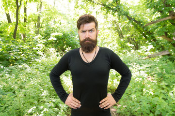Naklejka na ściany i meble Man bearded hipster bright foliage background. Guy relax in summer forest. Handsome man with beard and mustache summer vacation. Brutality of jungles concept. Summer heat season concept. Wild nature