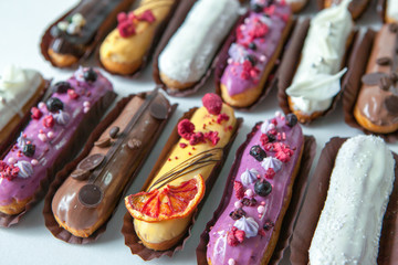 Obraz na płótnie Canvas Set of several eclairs with various fillings and design isolate on a white background, the concept of French cuisine