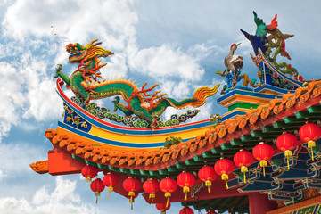 chineese dragon on roof of buddhism temple decration detail on cloudy sky background