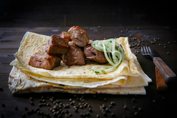 Grill dishes and pita for the restaurant menu. Wooden background. Grilled pork neck and onion