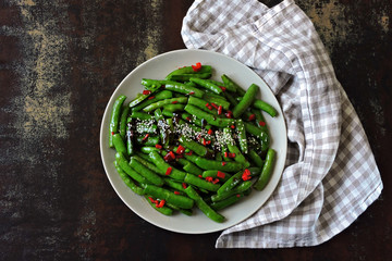 Young green pea pods with chili pepper and soy sauce. Vegan food. Dietary food.