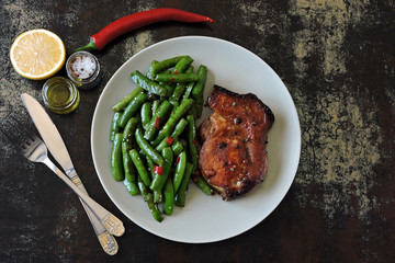 Green pea pods with chili pepper and soy sauce. Meat steak. An example of a balanced diet. Keto diet. Pegan Diet.