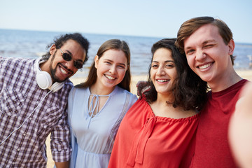 Group of happy young people posing at beach enjoying Summer, copy space