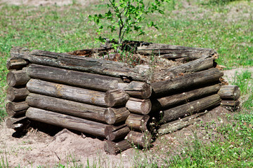 Fragment of the wall of the old ruined wooden house of logs.