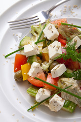 Mediterranean-style Salad with feta cheese, organic green olives, cherry tomatoes, cucumber, fresh basil and parsley. Greek salad. Healthy snack. Concept for a tasty and healthy meal.