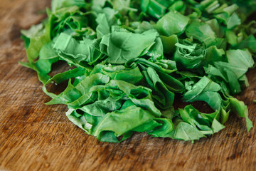 Fresh bright green spinach on a wooden board. Chopped spinach as a background.