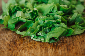 Fresh bright green spinach on a wooden board. Chopped spinach as a background.