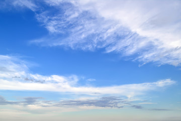 White cirrus and stratus clouds high in the blue summer sky. Different cloud types and atmospheric phenomena. Skyscape.