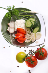 Salad with sour cream, onions, tomatoes and cucumbers on a transparent plate, close up