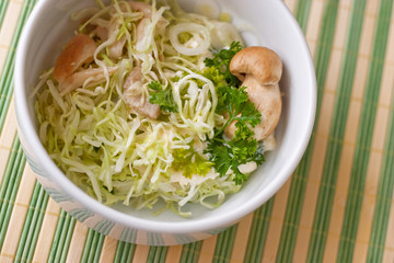 Salad with cabbage leaves and mushrooms in white bowl. close up.