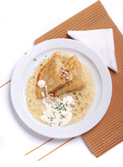 Rustic pancakes with meat on a plate in the form of a triangle, close up, decorated