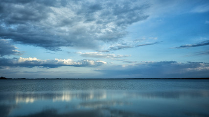 Beautiful blue background. Clouds reflected on the water. Switiaz Lake. Polesie. Ukraine