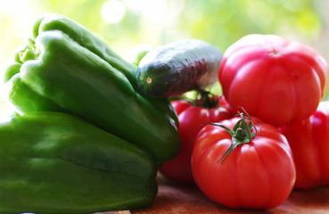 closeup of peppers, cucumber and red tomatoes