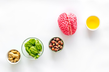 Brain food concept with peanut, hazelnut, seed-oil, spinage on white background top view copyspace