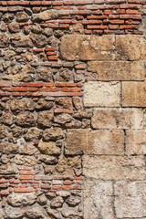 Composite old stone and bricks wall with rough surface as background