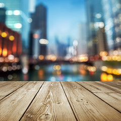 wooden table top with defocused evening city background