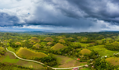 Aerial panorama of storm clouds behind the unique Chocolate Hills landscape in Bohol,Philippines