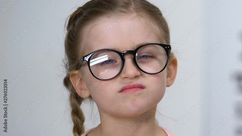 Sticker male ophthalmologist giving eyeglasses to small farsighted girl, health care