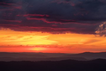 Fototapeta na wymiar Orange sky, clouds and mountains. Beautiful sunrise in the Bieszczady mountains. Poland