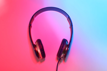 Stylish headphones on color background, top view