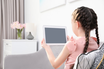 Cute girl using video chat on tablet at home, space for text