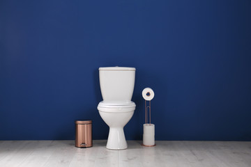 Simple bathroom interior with new toilet bowl near color wall