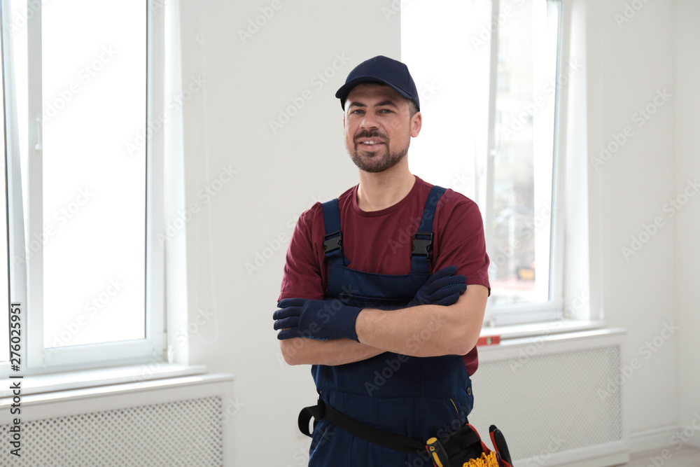 Wall mural portrait of professional construction worker with tool belt indoors