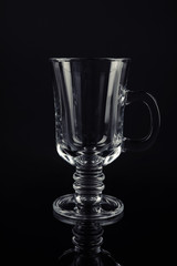 Clean empty mulled wine glass on black background