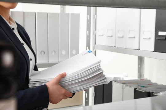 Female worker with documents in office, closeup