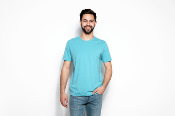Young man in t-shirt on light background. Mock up for design