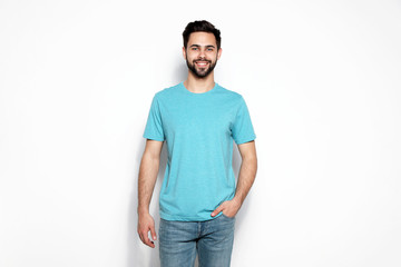 Fototapeta premium Young man in t-shirt on light background. Mock up for design