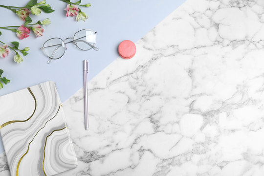 Flat Lay Composition With Notebook, Glasses And Macaron On Marble Table, Space For Text