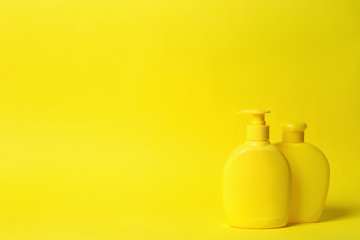 Bottles of shampoo on yellow background, space for text. Natural cosmetic products