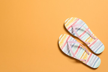 Bright flip flops on color background, top view with space for text. Beach accessories