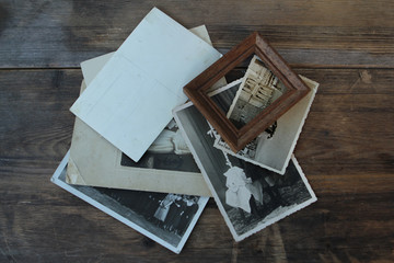 Retro some old photos and photo frame on old natural wooden table