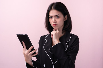 Cute asian woman thinking and curious isolated on pink background